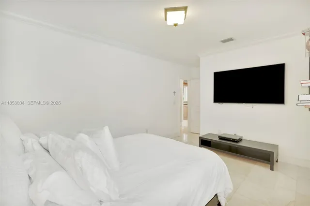 a bedroom with a bed tv and a flat screen tv