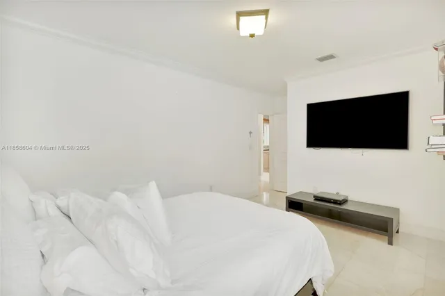 a bedroom with a bed tv and a flat screen tv