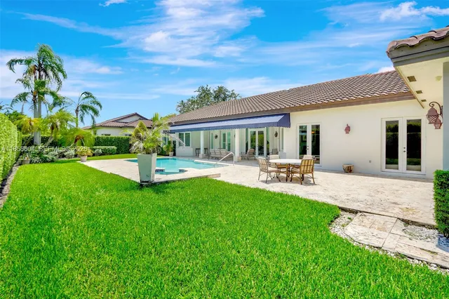 a view of a patio with couches and table and chairs under an umbrella