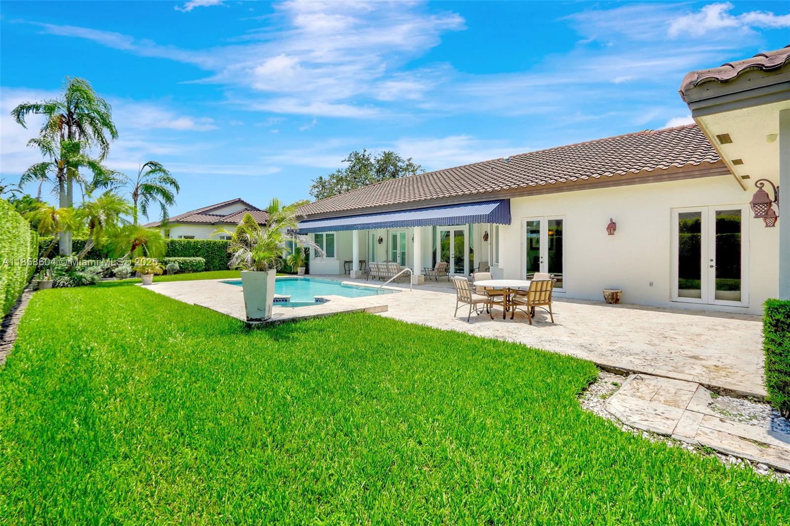 7261 Southwest 120th Avenue Miami, FL 33183 - Photo 43 of 50 a view of a patio with couches and table and chairs under an umbrella