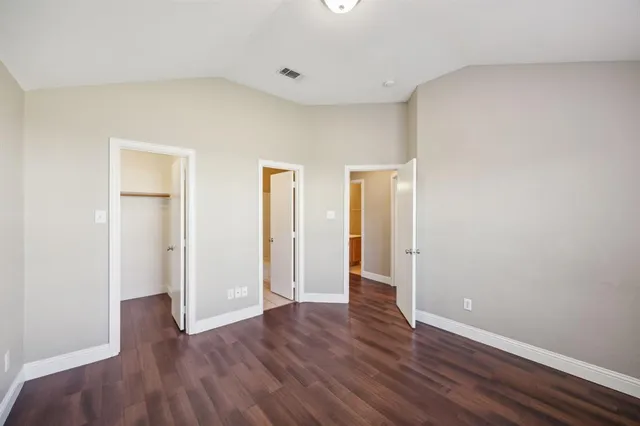 an empty room with wooden floor and closet