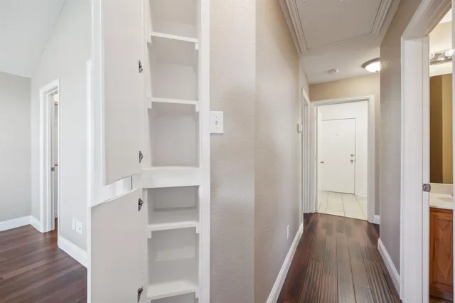 a view of a hallway with wooden floor and closet area