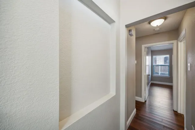 a view of a hallway with wooden floor