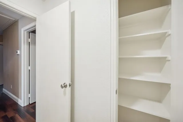 a view of walk in closet with empty racks