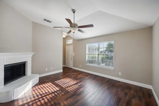 a view of an empty room with a fireplace and a window