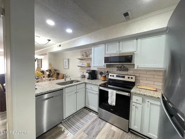 a kitchen with a sink stove and microwave
