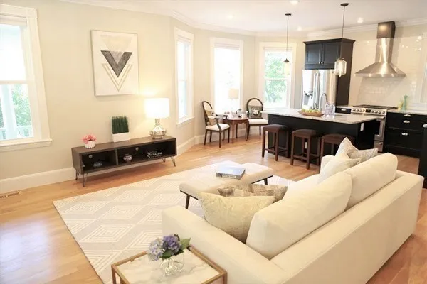 a living room with furniture kitchen view and a window