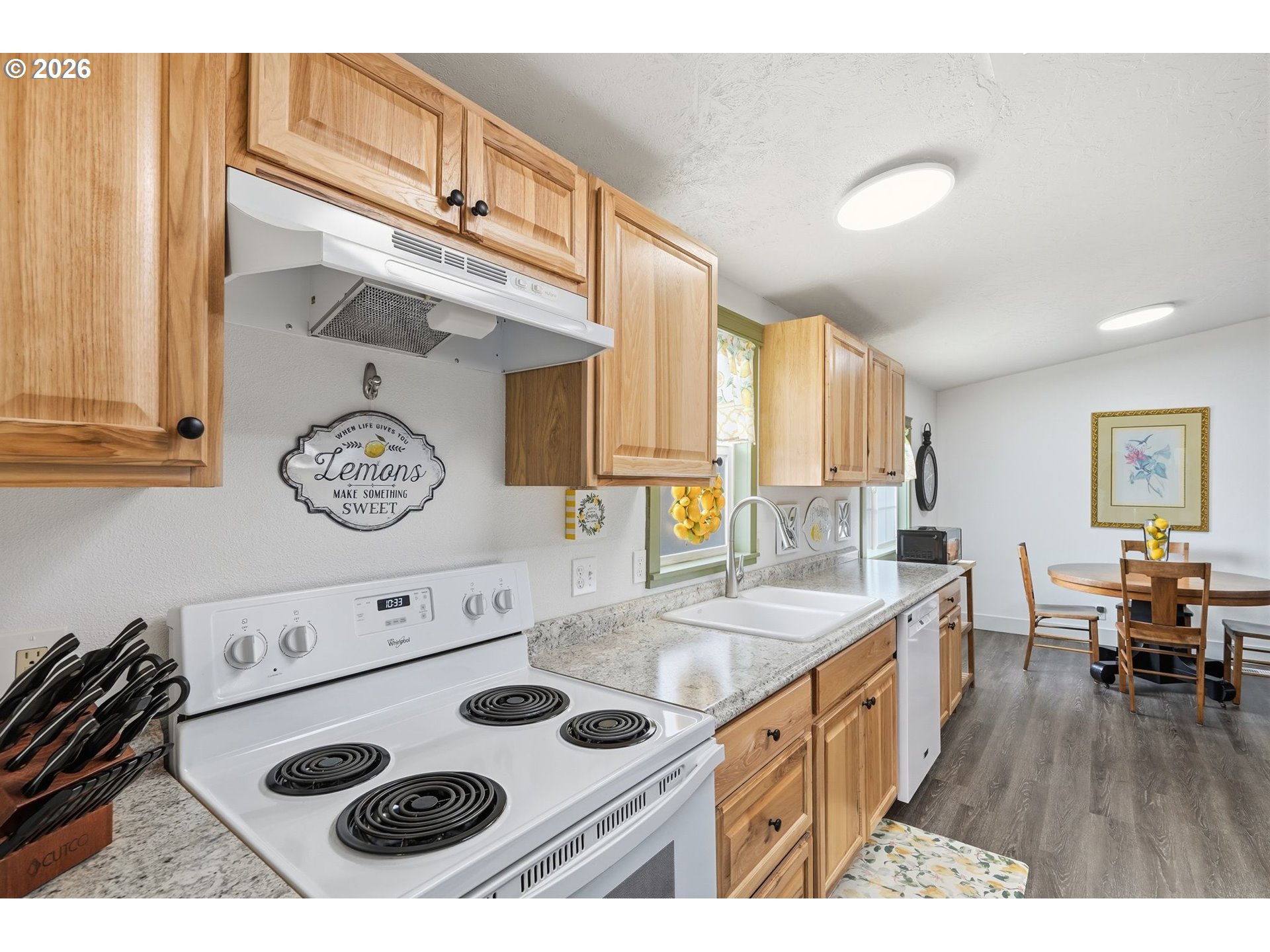 300 Southwest 7th Street, Unit 508 Battle Ground, WA 98604 - Photo 12 of 38 a kitchen with a table chairs and a stove top oven with wooden floor