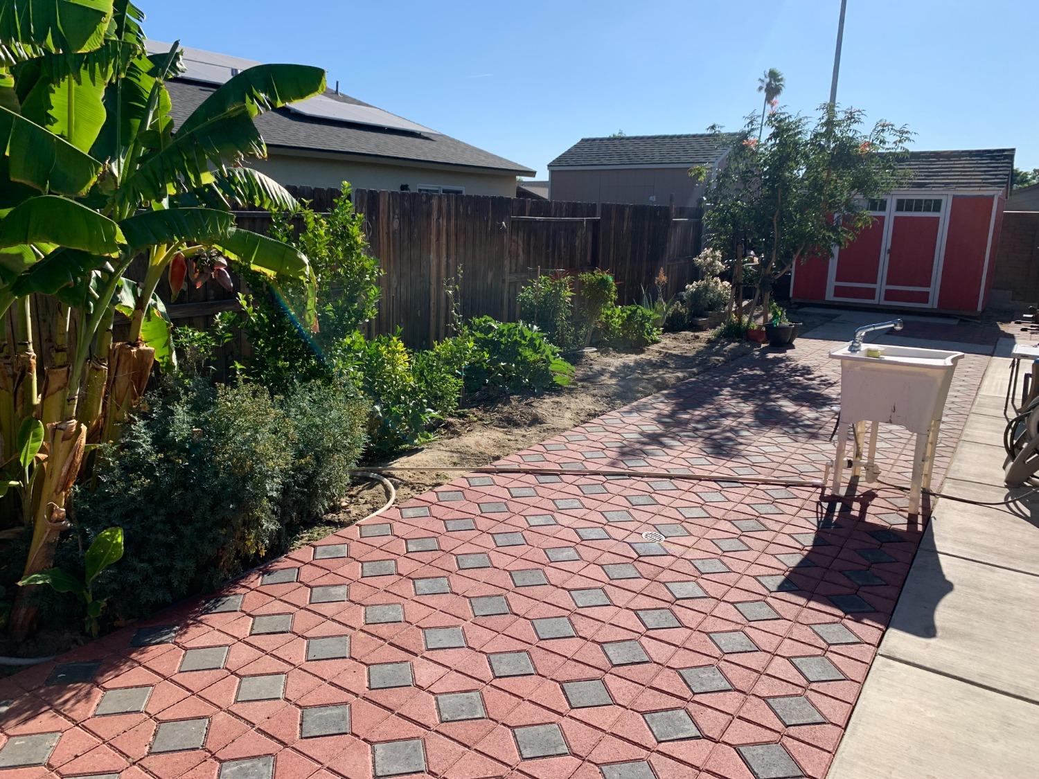 348 Silva Street Mendota, CA 93640 - Photo 11 of 24 a view of backyard with potted plants and a bench