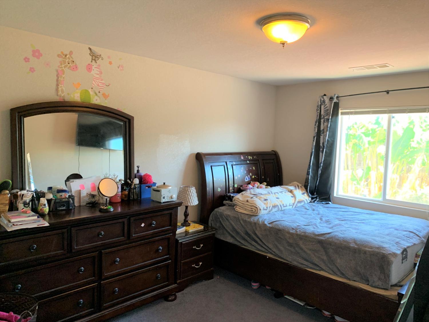 348 Silva Street Mendota, CA 93640 - Photo 16 of 24 a bedroom with a bed and a mirror