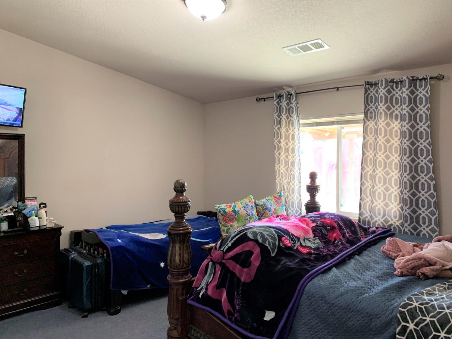 348 Silva Street Mendota, CA 93640 - Photo 18 of 24 a bedroom with a bed and a window