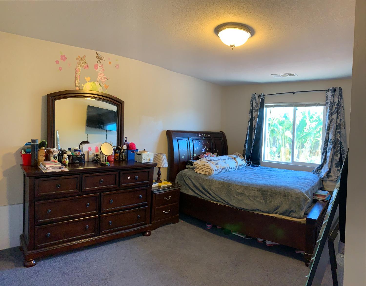 348 Silva Street Mendota, CA 93640 - Photo 19 of 24 a bed room with a bed and a mirror