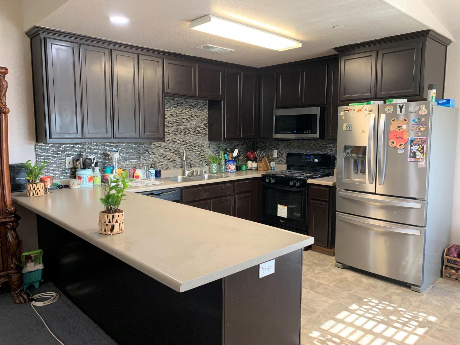 348 Silva Street Mendota, CA 93640 - Photo 7 of 24 a kitchen with a sink a refrigerator and a stove top oven