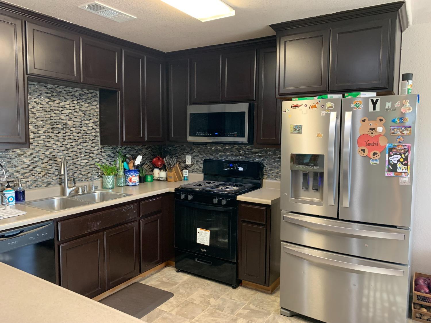348 Silva Street Mendota, CA 93640 - Photo 8 of 24 a kitchen with stainless steel appliances wooden cabinets and a sink
