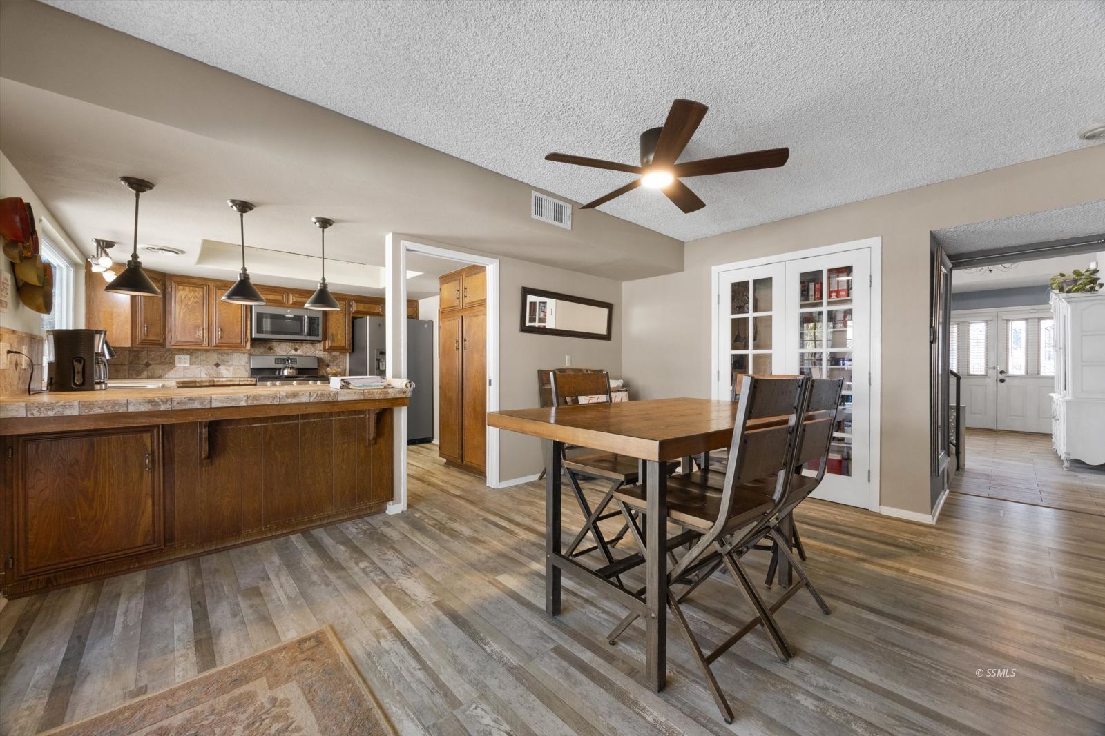 736 Fendrick Circle Ridgecrest, CA 93555 - Photo 16 of 49 a kitchen with stainless steel appliances kitchen island granite countertop wooden floors and white cabinets