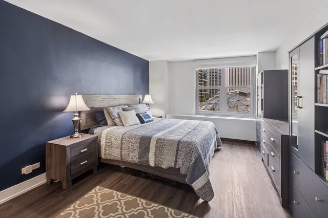 a bedroom with a bed and a refrigerator