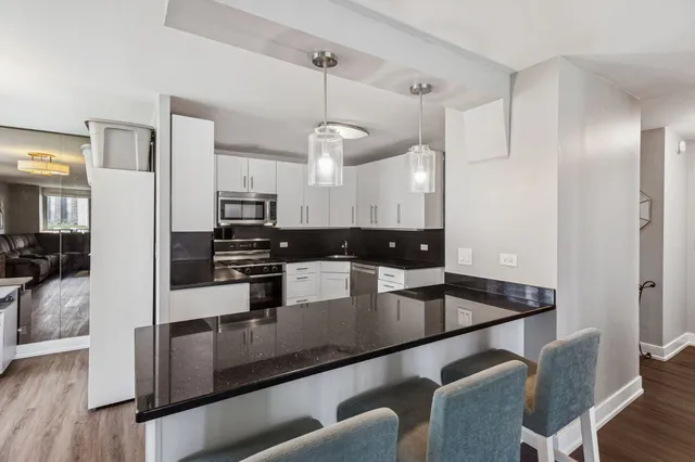 a kitchen with stainless steel appliances granite countertop a sink a stove and refrigerator