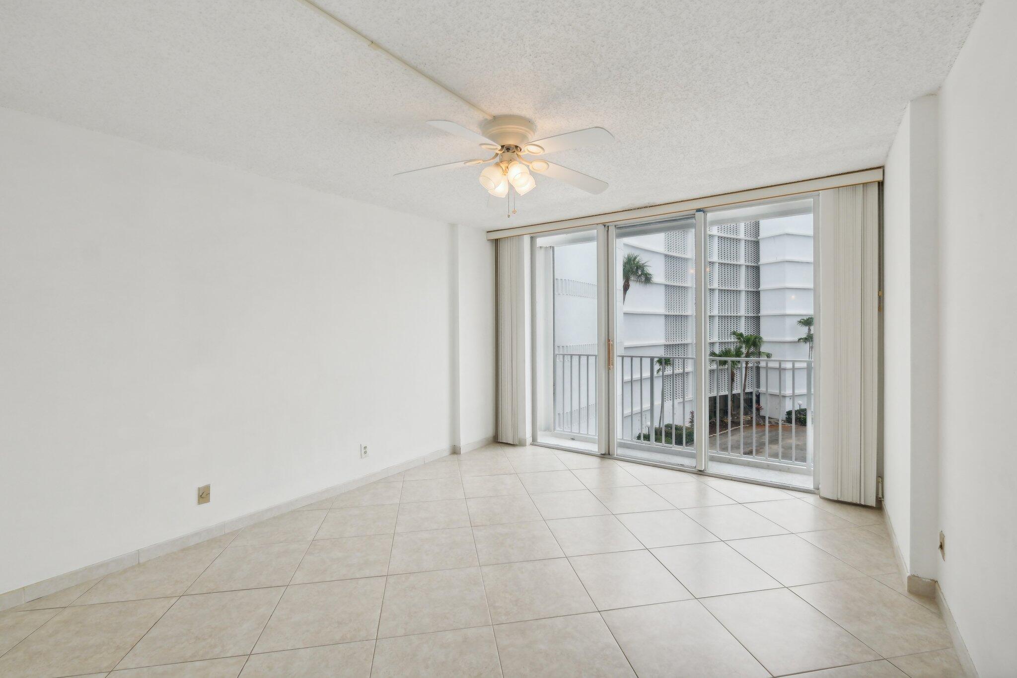 3580 South Ocean Boulevard, Unit 4C South Palm Beach, FL 33480 - Photo 13 of 36 en empty room with windows and ceiling fan