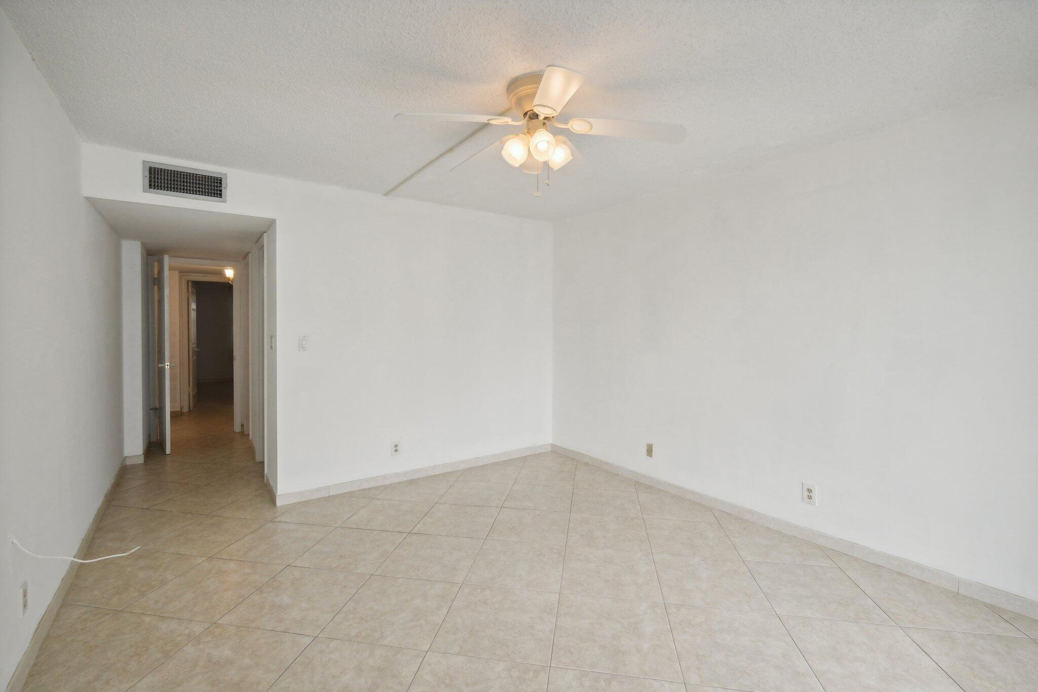 3580 South Ocean Boulevard, Unit 4C South Palm Beach, FL 33480 - Photo 15 of 36 an empty room with a chandelier fan and entryway