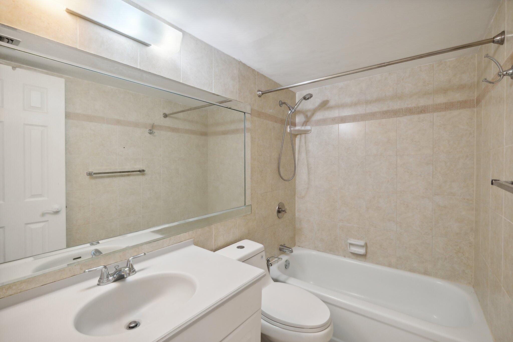 3580 South Ocean Boulevard, Unit 4C South Palm Beach, FL 33480 - Photo 16 of 36 a bathroom with a sink mirror toilet and bathtub