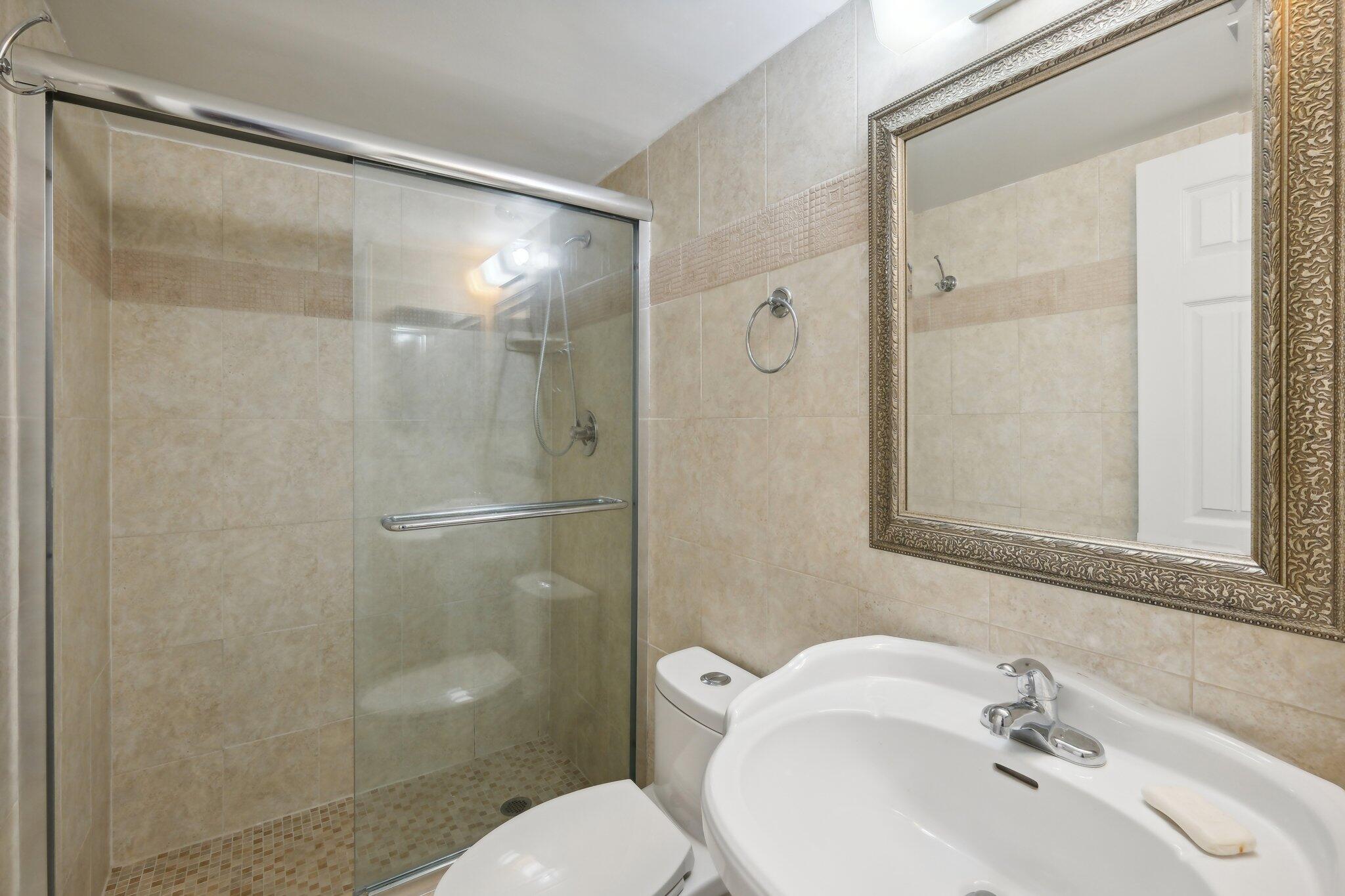 3580 South Ocean Boulevard, Unit 4C South Palm Beach, FL 33480 - Photo 21 of 36 a bathroom with a sink and mirror with toilet