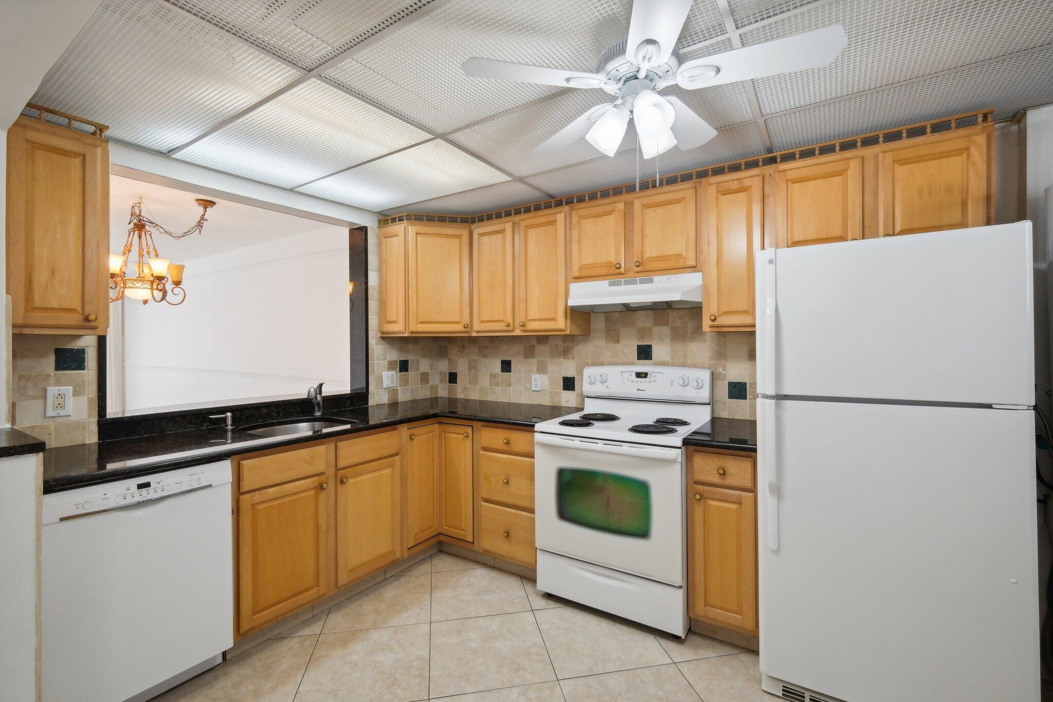 3580 South Ocean Boulevard, Unit 4C South Palm Beach, FL 33480 - Photo 4 of 36 a kitchen with a white cabinets and white appliances
