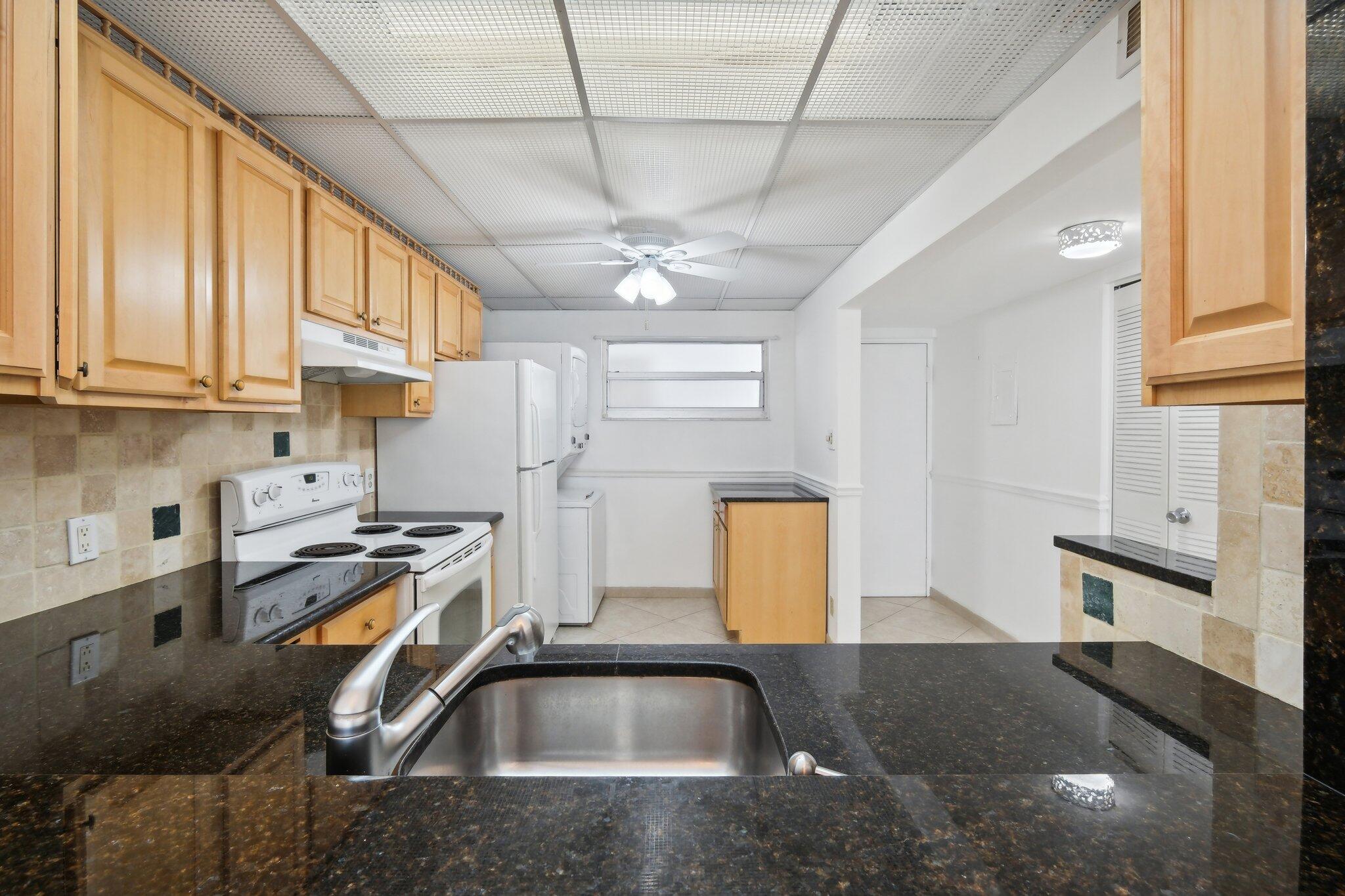 3580 South Ocean Boulevard, Unit 4C South Palm Beach, FL 33480 - Photo 6 of 36 a kitchen with a sink a counter top space and stainless steel appliances