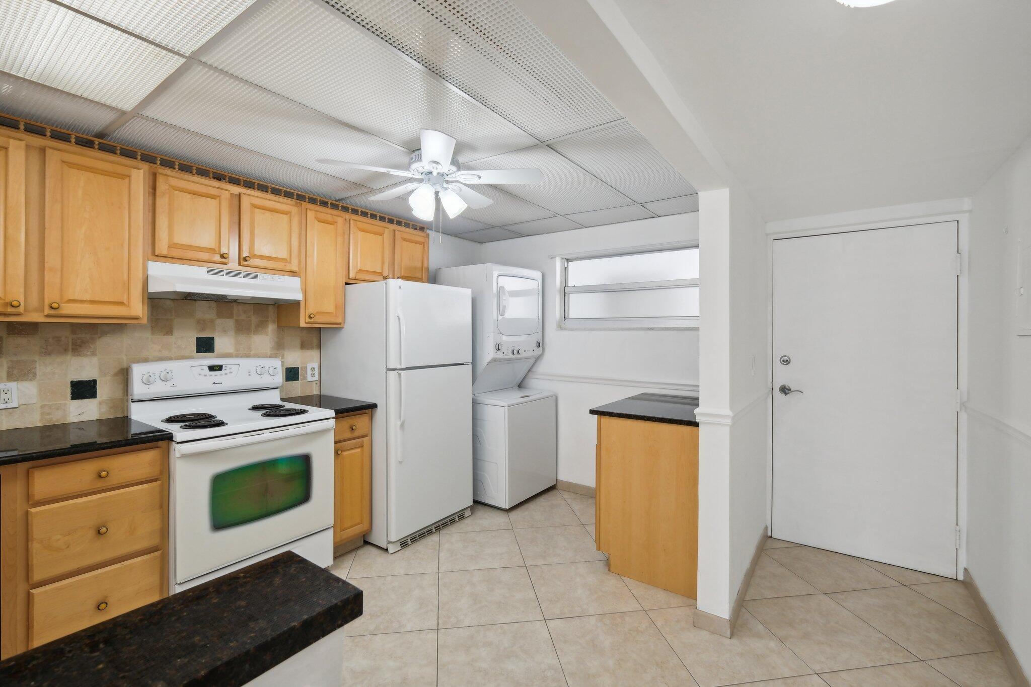 3580 South Ocean Boulevard, Unit 4C South Palm Beach, FL 33480 - Photo 7 of 36 a kitchen with a stove top oven cabinets and a refrigerator