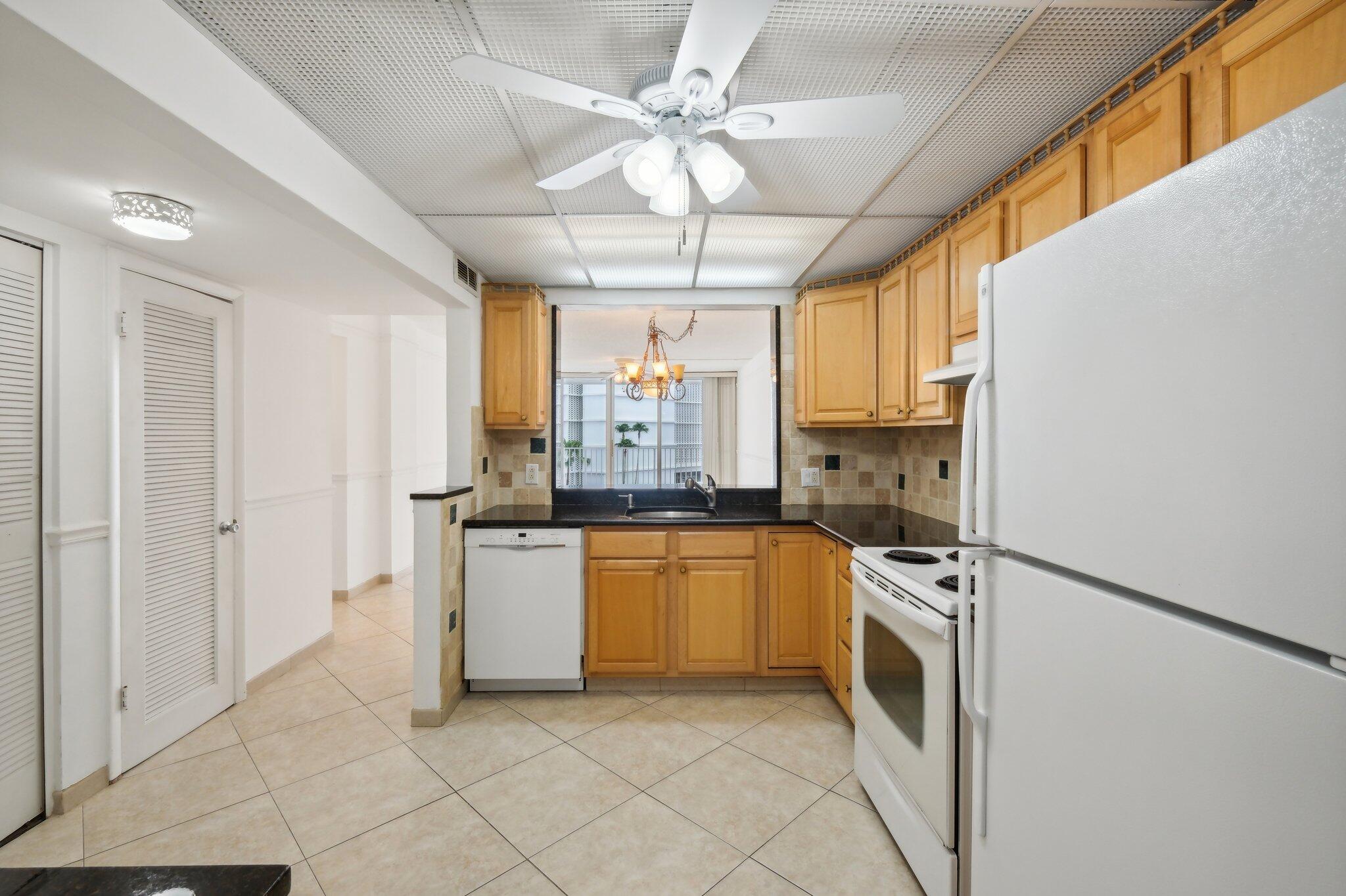 3580 South Ocean Boulevard, Unit 4C South Palm Beach, FL 33480 - Photo 8 of 36 a kitchen with a refrigerator a sink and dishwasher