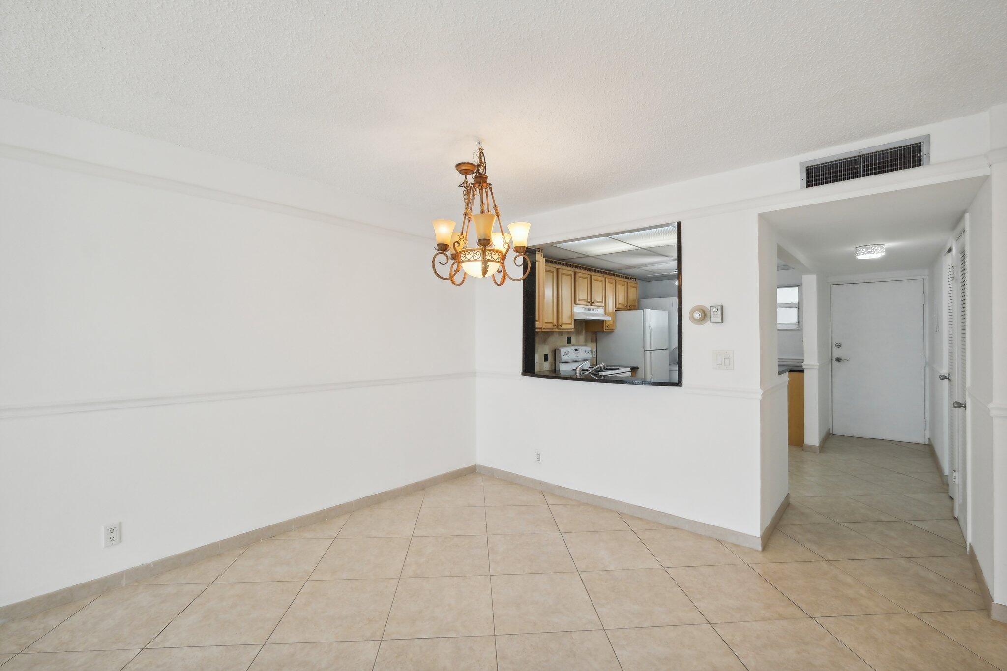 3580 South Ocean Boulevard, Unit 4C South Palm Beach, FL 33480 - Photo 9 of 36 a view of a hallway with a chandelier