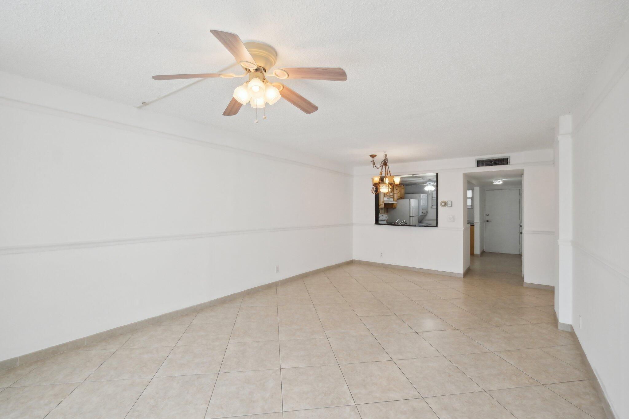3580 South Ocean Boulevard, Unit 4C South Palm Beach, FL 33480 - Photo 10 of 36 an empty room with windows and ceiling fan