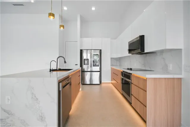 a large kitchen with stainless steel appliances granite countertop a lot of counter space and wooden floor