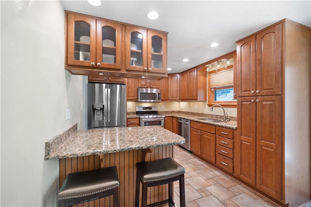 2027 Cutter Drive McKees Rocks, PA 15136 - Photo 5 of 22 a kitchen with kitchen island granite countertop wooden cabinets and a refrigerator