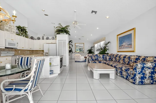 a kitchen with kitchen island granite countertop lots of white cabinets and stainless steel appliances