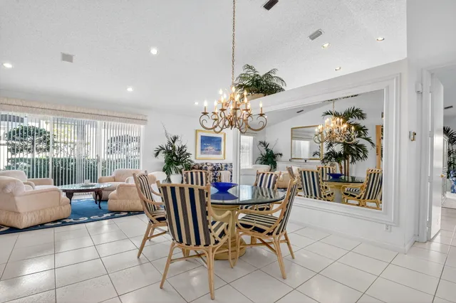 a dining room filled chandelier and wooden floor