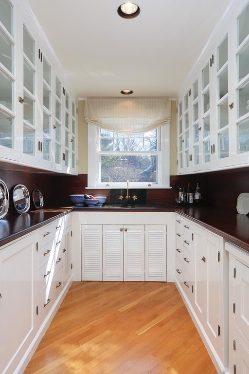 55 Devon Road Brookline, MA 02467 - Photo 6 of 12 a large white kitchen with granite countertop a sink a stove a window and white stainless steel appliances