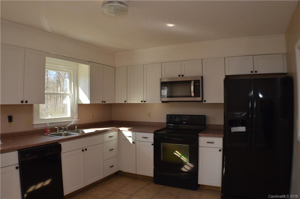 266 Cardinal Road Spindale, NC 28139 - Photo 5 of 15 a kitchen with granite countertop white cabinets and stainless steel appliances