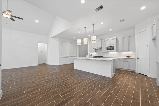 a large kitchen with kitchen island a sink stainless steel appliances and cabinets