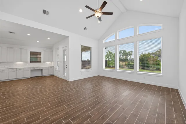 a view of an empty room with a window and wooden floor