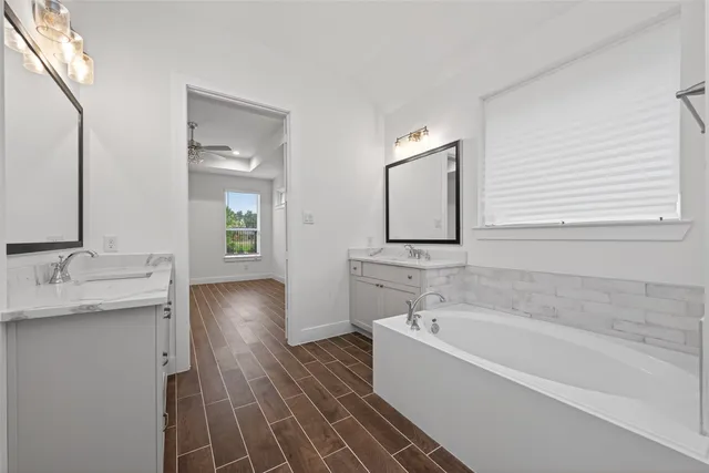 a white bath tub sitting next to a bathroom sink
