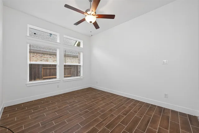 a view of an empty room with a window and a ceiling fan