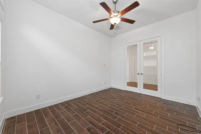an empty room with closet and a ceiling fan