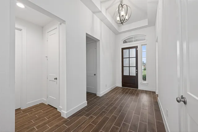 an empty room with wooden floor cabinet and windows