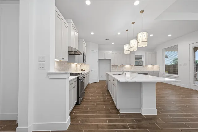 a kitchen with kitchen island a sink stainless steel appliances and cabinets