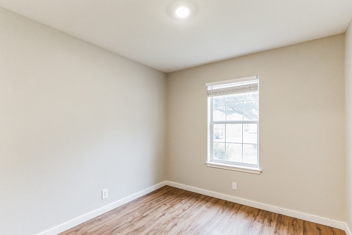313 Caladium Drive Georgetown, TX 78626 - Photo 22 of 36 an empty room with wooden floor and windows