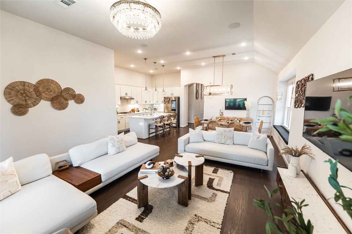 608 Pecan Bottom Trail Georgetown, TX 78628 - Photo 10 of 30 Living room featuring a chandelier, dark wood-style flooring, recessed lighting, arched walkways, and lofted ceiling