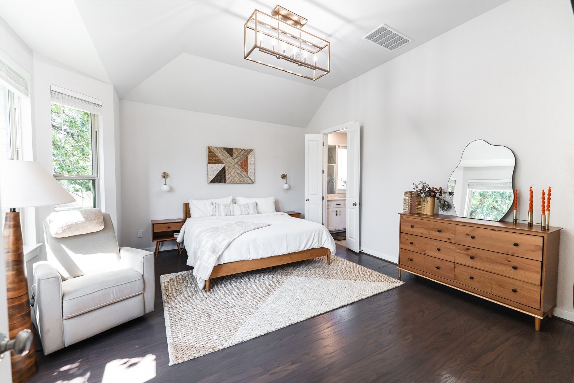608 Pecan Bottom Trail Georgetown, TX 78628 - Photo 11 of 30 Bedroom featuring lofted ceiling, multiple windows, dark wood finished floors, a chandelier, and connected bathroom