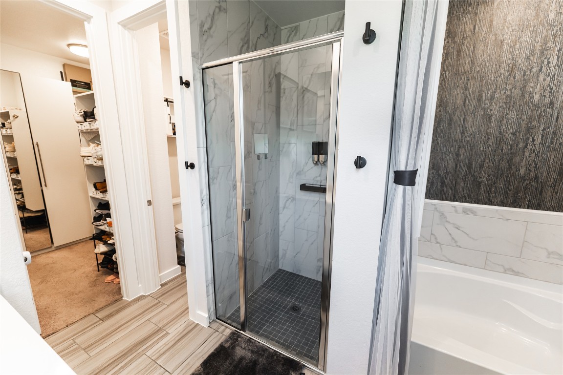 608 Pecan Bottom Trail Georgetown, TX 78628 - Photo 14 of 30 Full bath featuring a walk in closet, a marble finish shower, and a garden tub