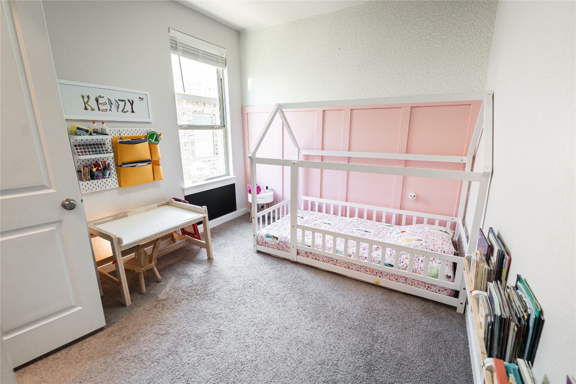 608 Pecan Bottom Trail Georgetown, TX 78628 - Photo 18 of 30 Bedroom with light colored carpet and a crib