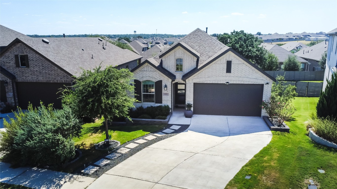 608 Pecan Bottom Trail Georgetown, TX 78628 - Photo 2 of 30 French country home featuring brick siding, driveway, a garage, a front lawn, and a residential view